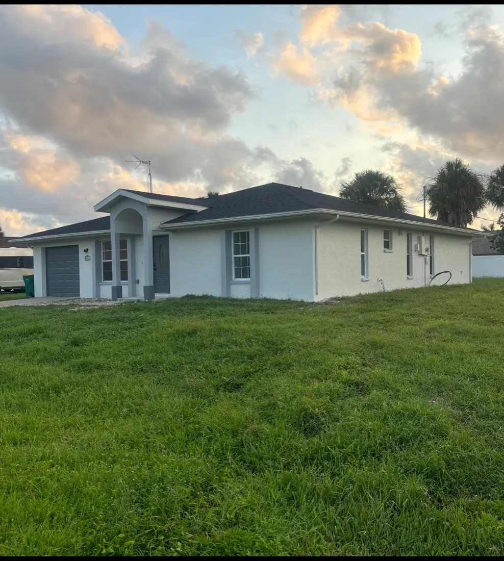 Homestead FL home exterior after repainting, white stucco with blue-gray trim
