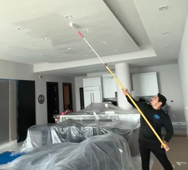 GXG Remodeling crew painting a ceiling on a job site