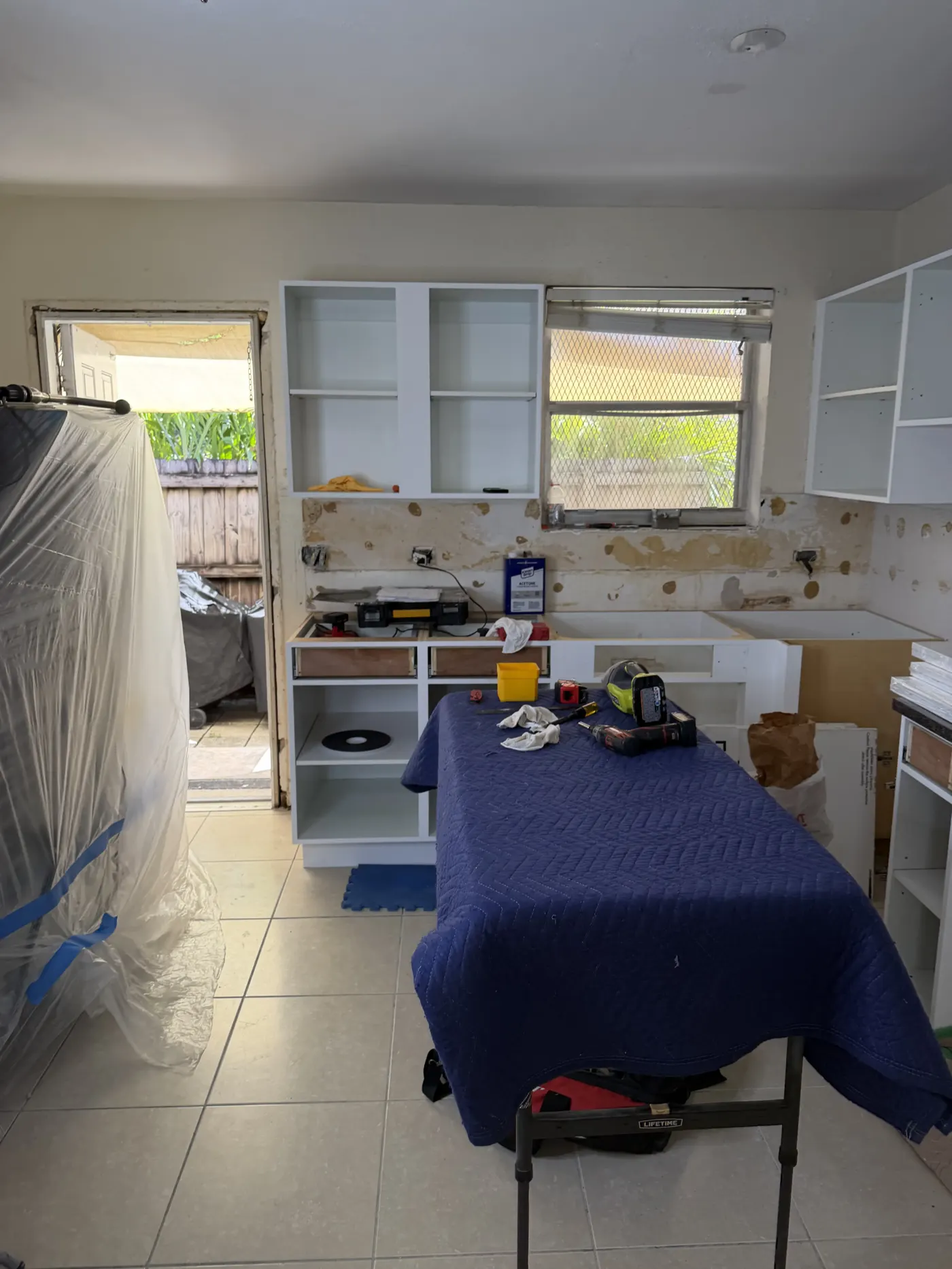 Kitchen cabinet installation in progress in Homestead, FL, upper cabinets mounted